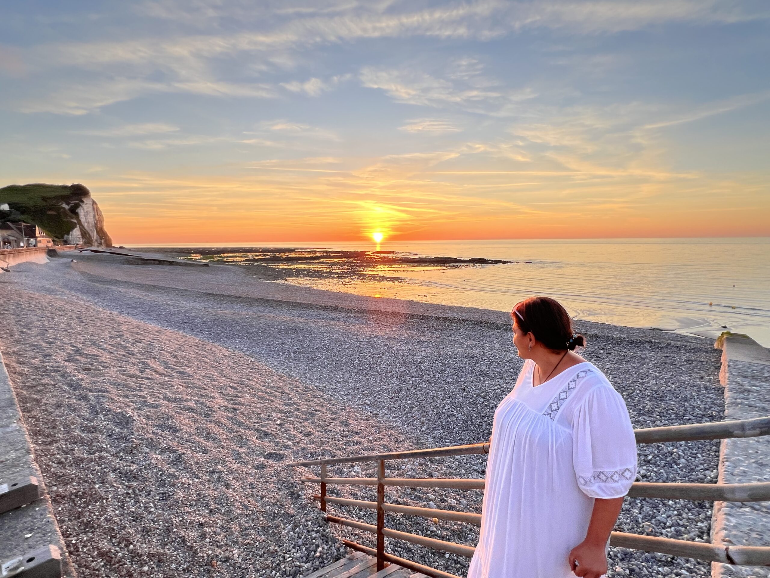Résidente contemplant un coucher de soleil sur la plage